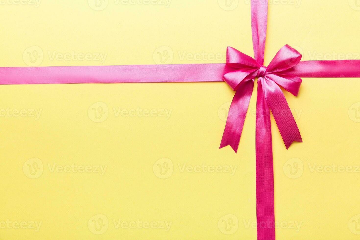 Top view of purple ribbon rolled and pink bow isolated on colored background. Flat lay with copy space photo