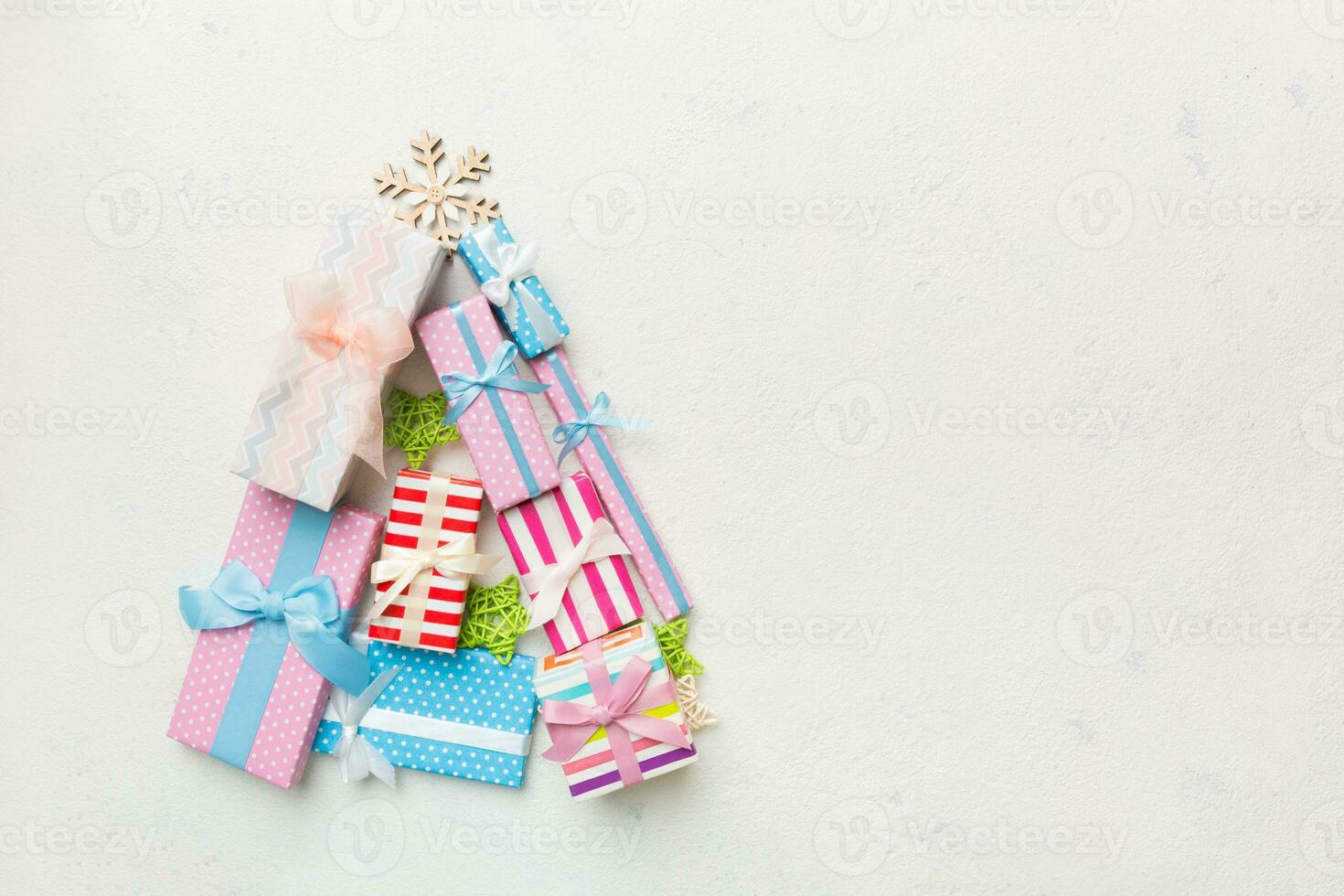 Christmas tree made of beautifuly wrapped presents on colored background, view from above. New Year gift box minimal concept with copy space photo