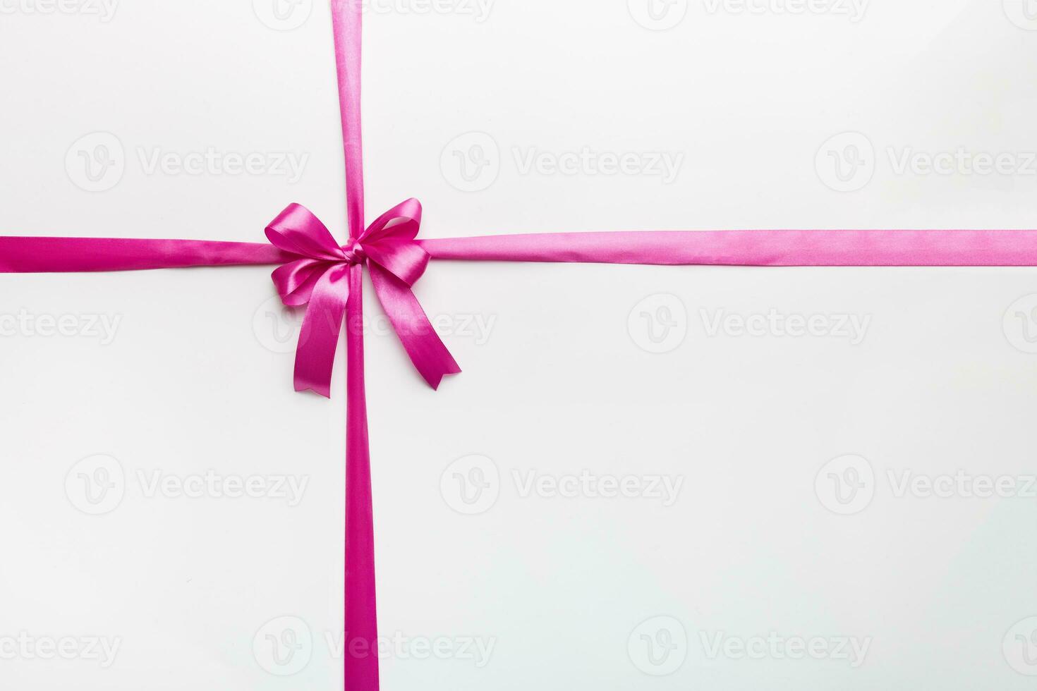 Top view of purple ribbon rolled and pink bow isolated on colored background. Flat lay with copy space photo