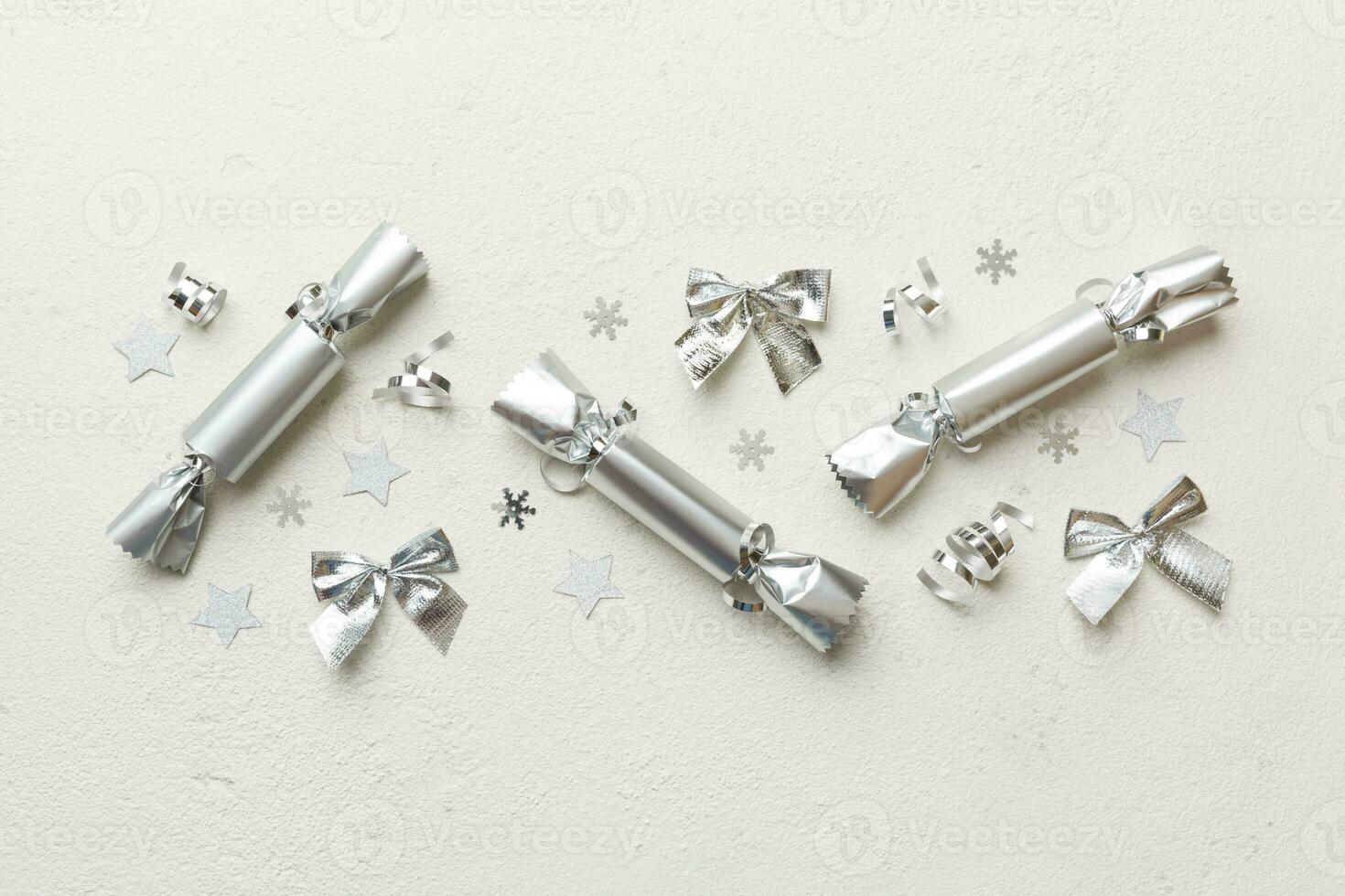 Christmas crackers with shiny confetti on color background, top view, copy space photo