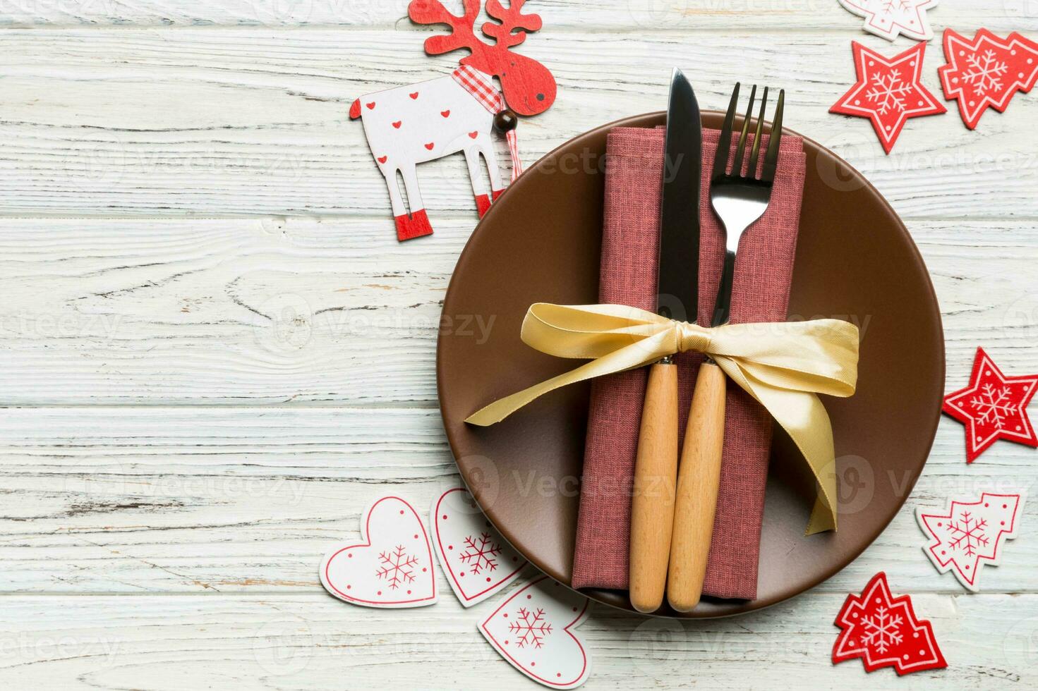 Top view of plate, fork and knife served on Christmas decorated wooden background. New Year Eve concept with copy space photo