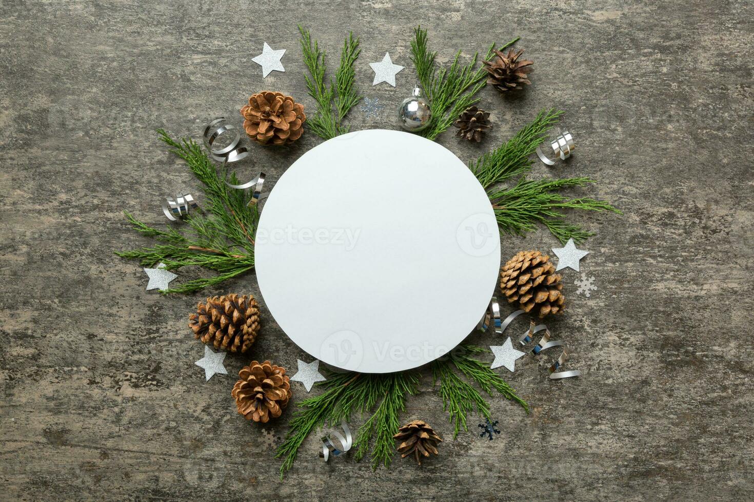 Flat lay Christmas composition. Round Paper blank, pine tree branches, christmas decorations on Colored background. Top view, copy space for text photo