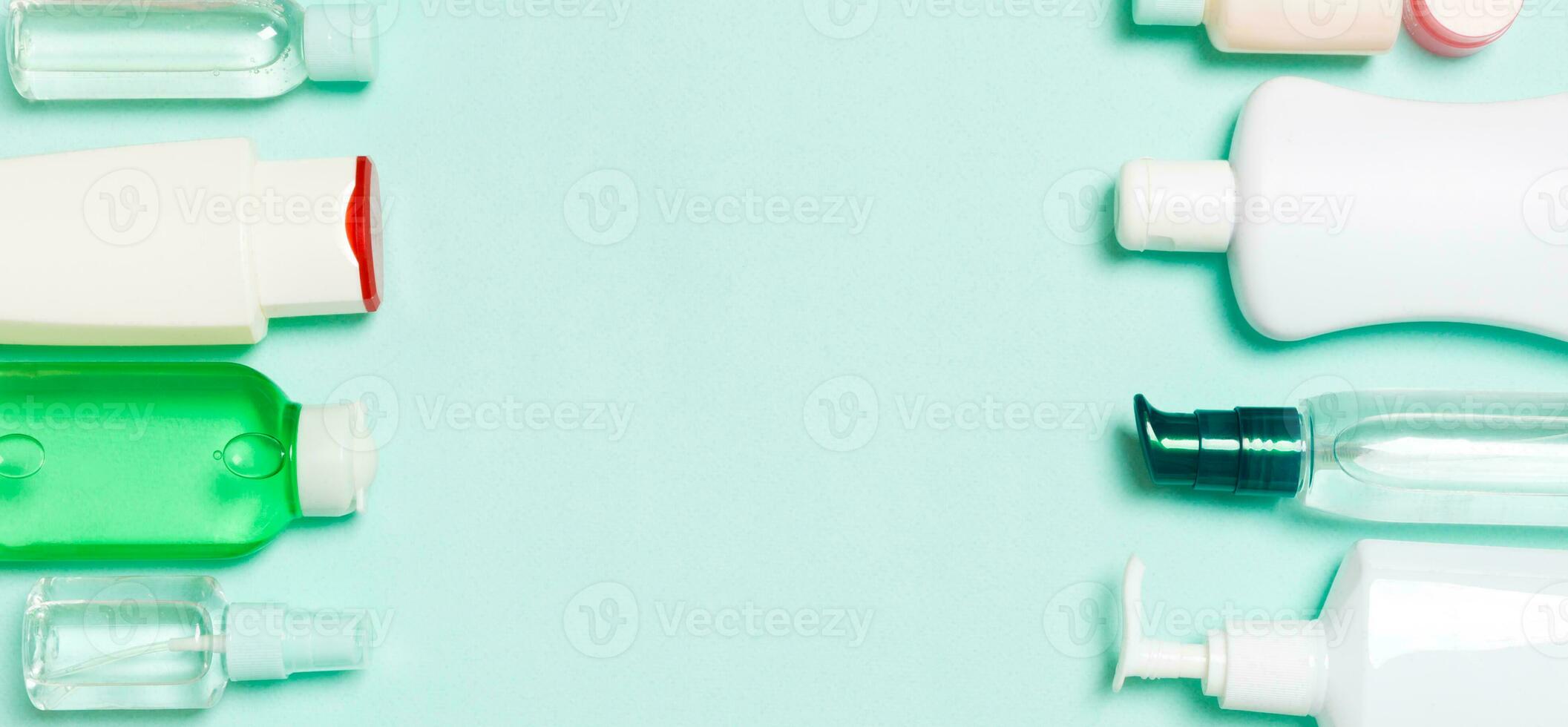 Top view of cosmetic products in different jars and bottles on blue background. Close-up of containers with copy space photo