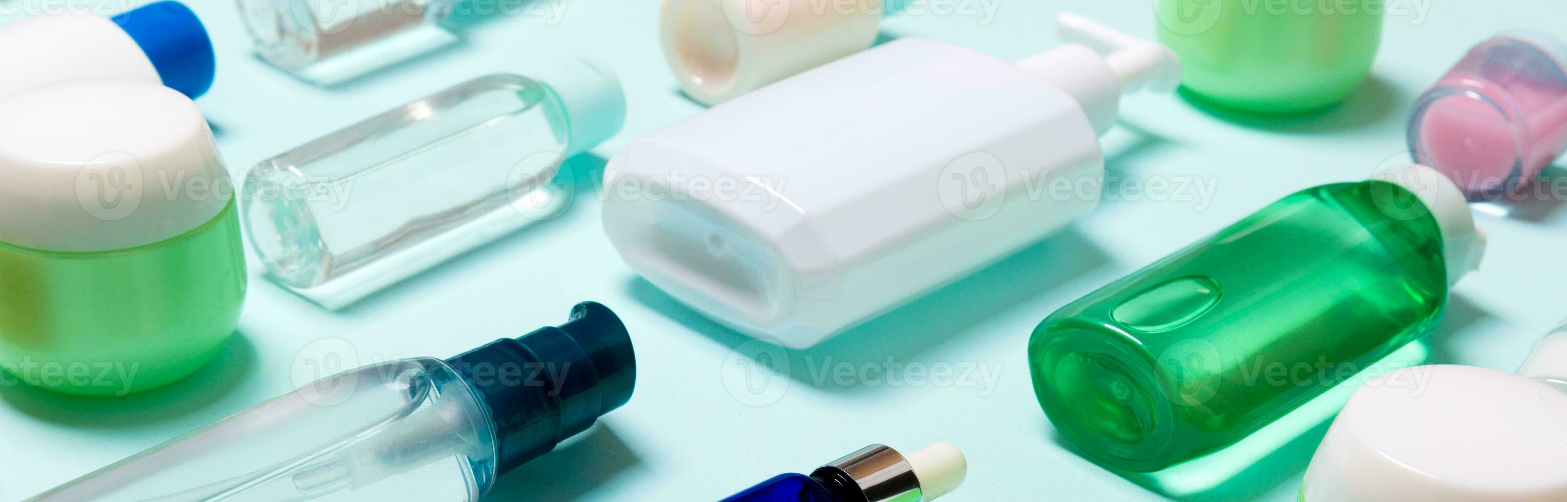 Top view of cosmetic products in different jars and bottles on blue background. Close-up of containers with copy space photo