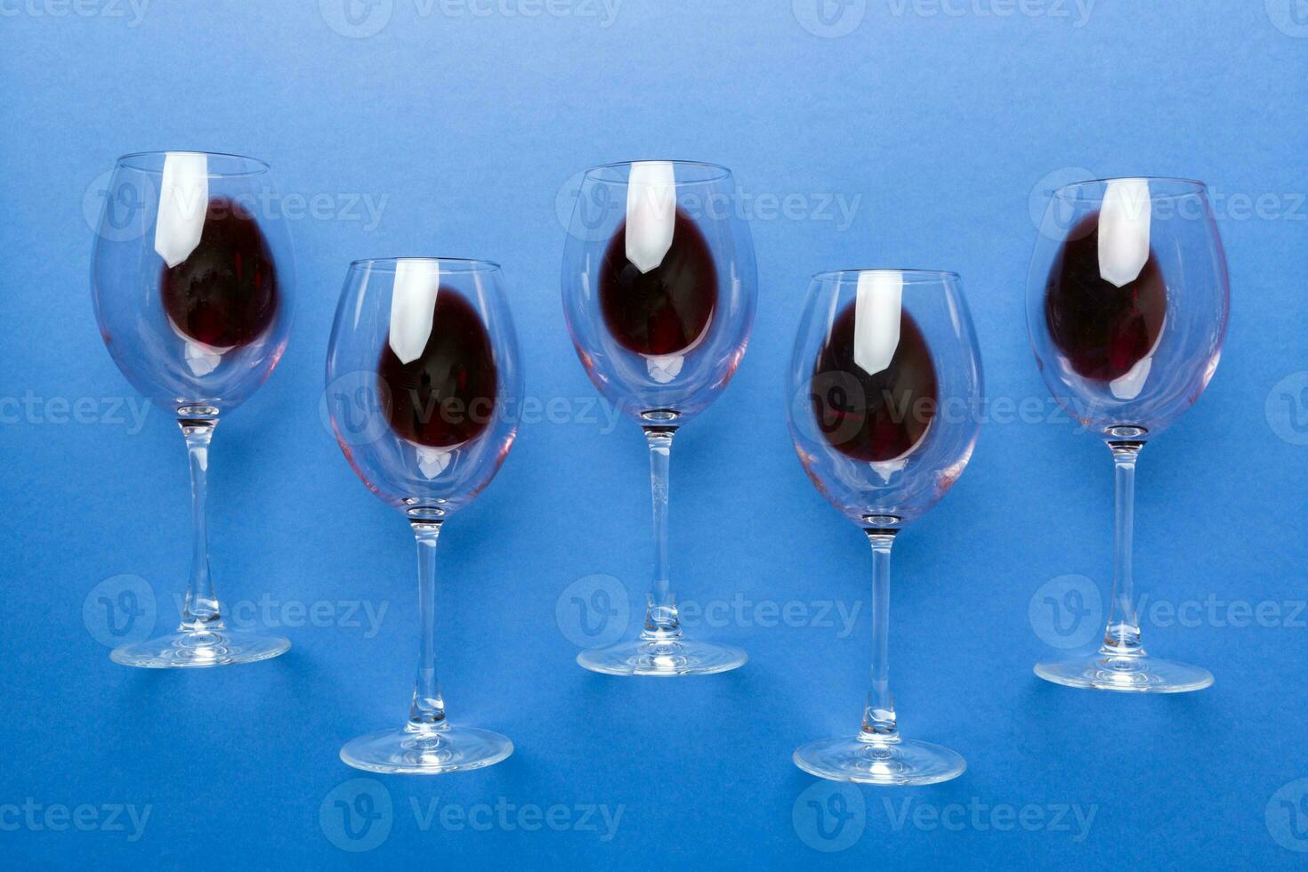 Many glasses of red wine at wine tasting. Concept of red wine on colored background. Top view, flat lay design photo