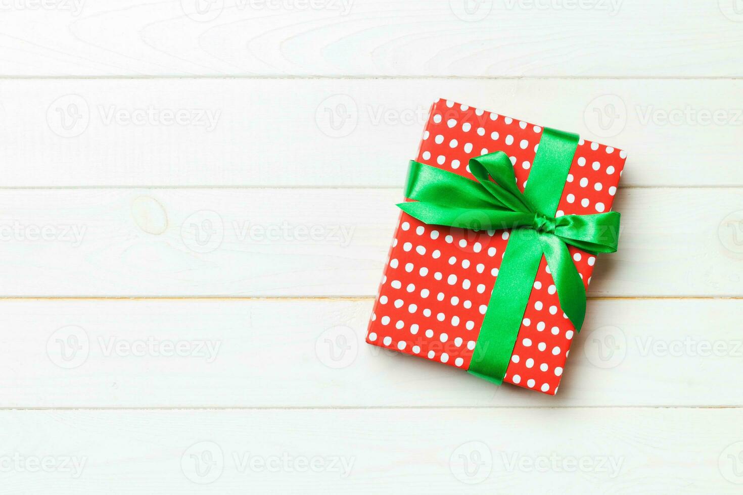 Beautiful gift box with a colored bow on the white wooden table. Top view banner with copy space for you design photo