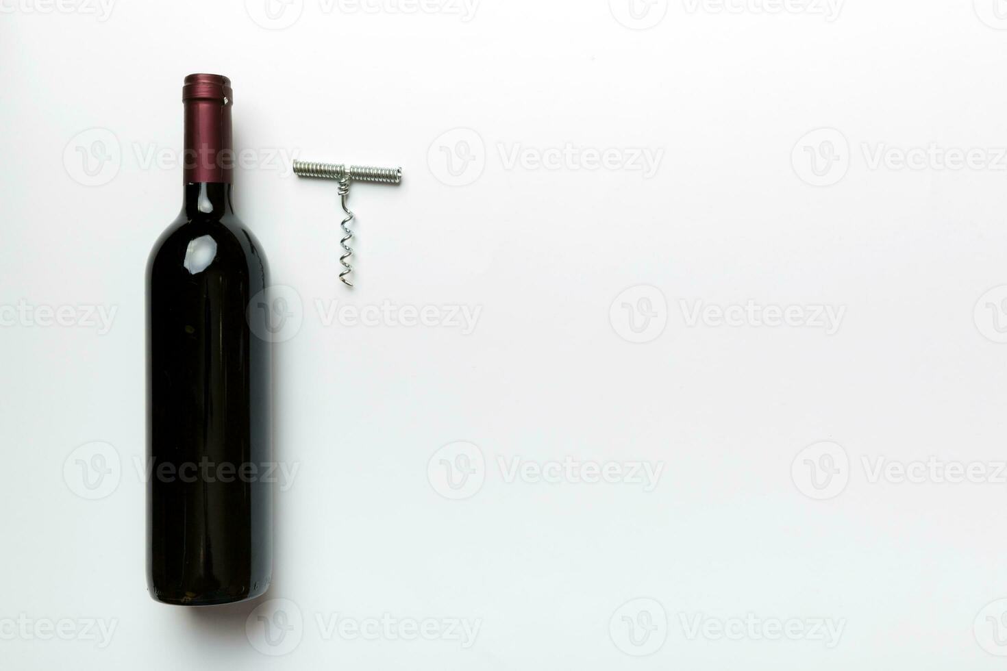 One Bottle of red wine with corkscrew on colored table. Flat lay, top view wth copy space photo