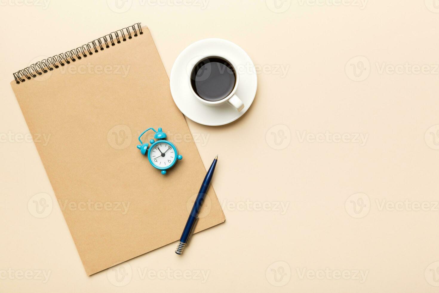 Modern office desk table with notebook and other supplies with cup of coffee. Blank notebook page for you design. Top view, flat lay photo
