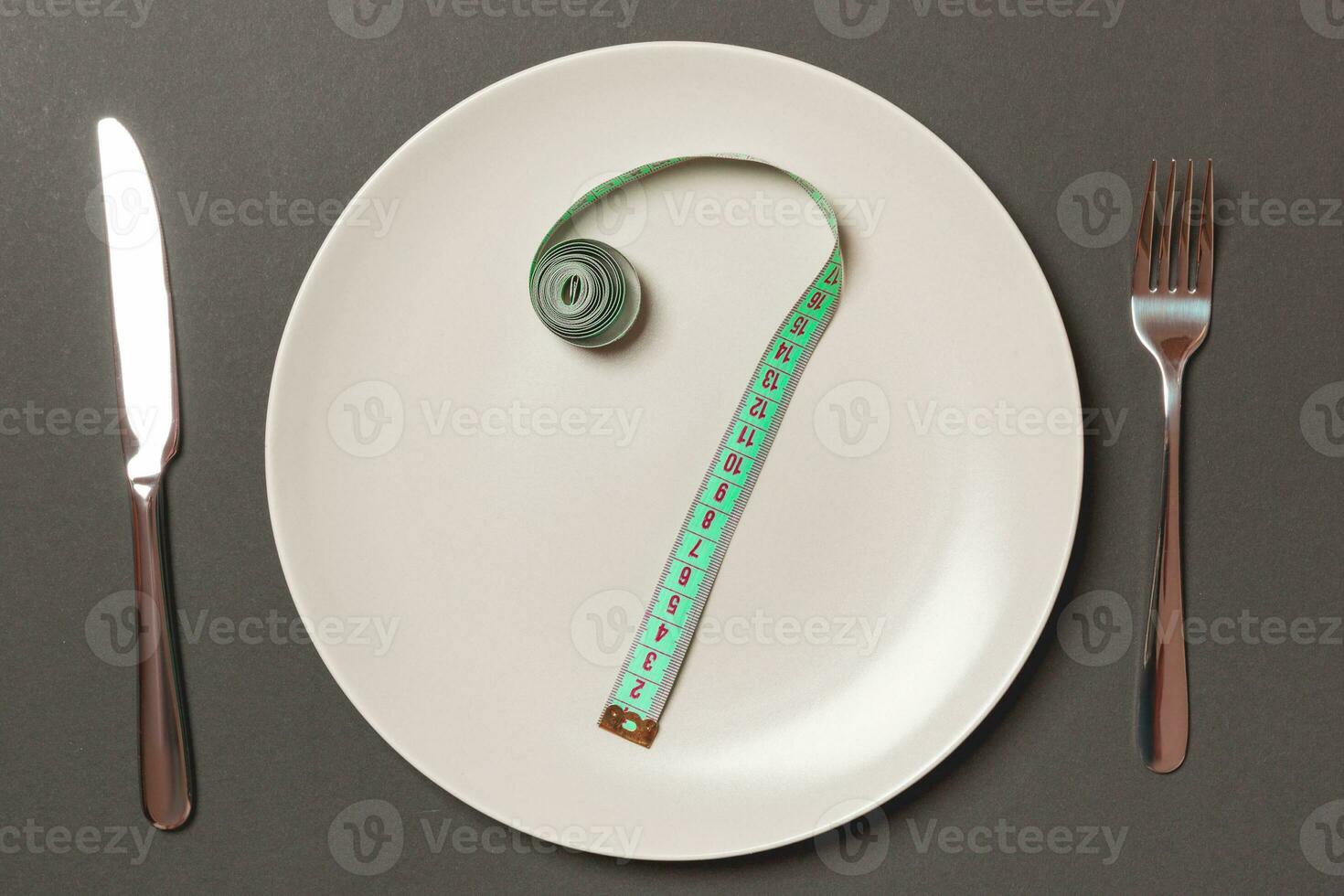 Fork and plate with measuring tape on color background. Diet concept photo