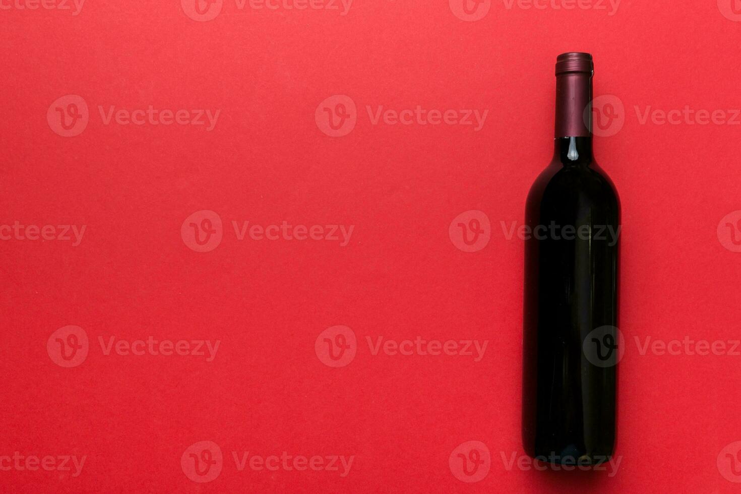 One Bottle of red wine on colored table. Flat lay, top view wth copy space photo