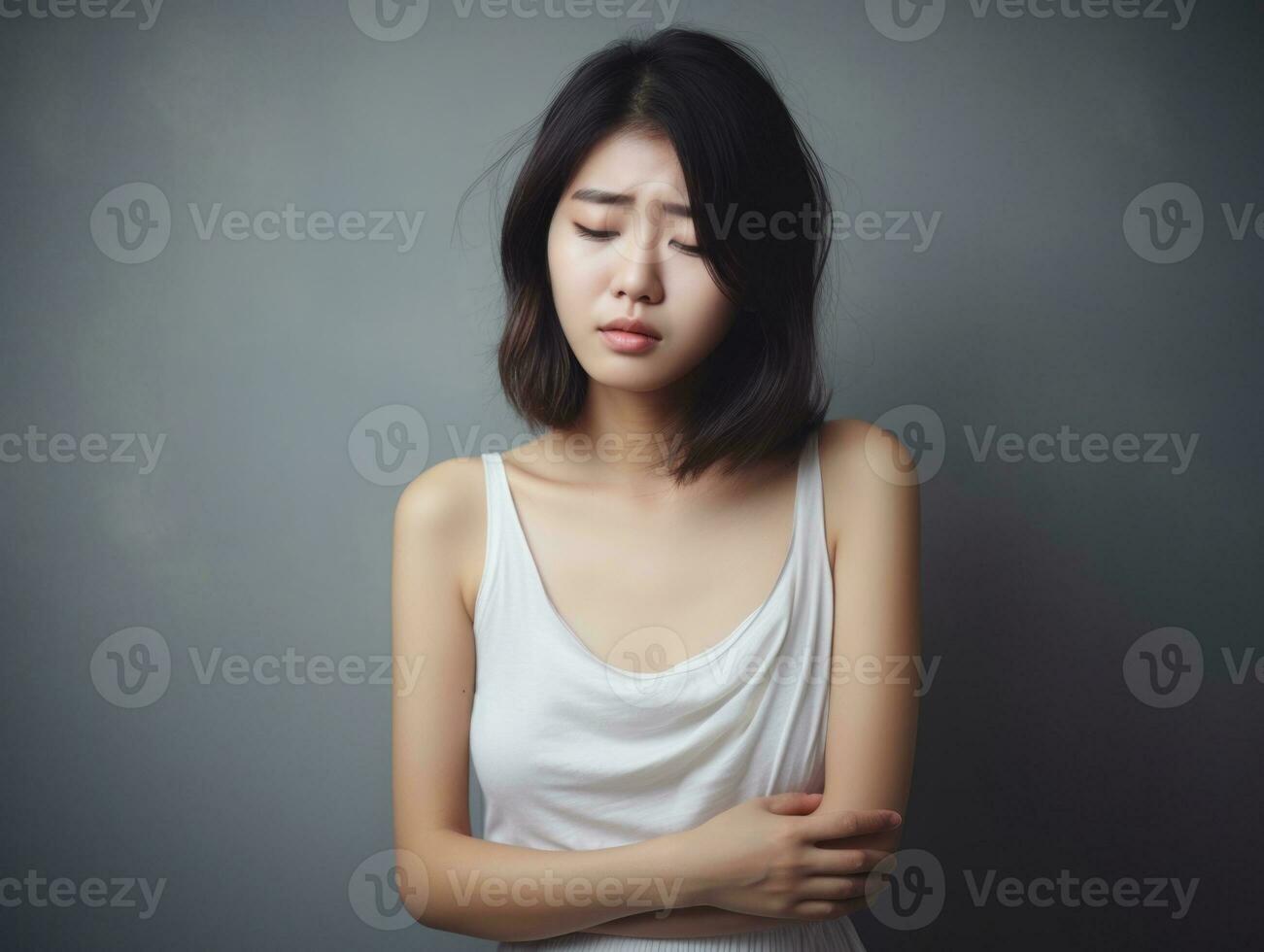 Asian woman appears to be in pain on grey background AI Generative photo