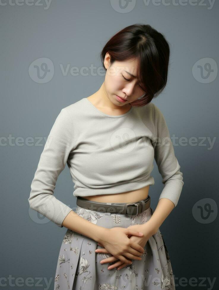 Asian woman appears to be in pain on grey background AI Generative photo