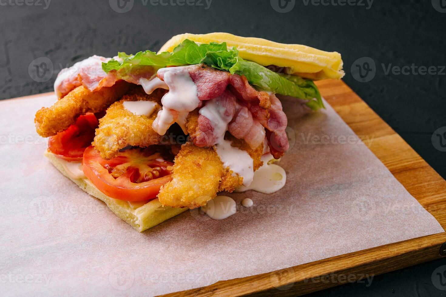 delicious waffle and chicken nuggets on wooden board photo