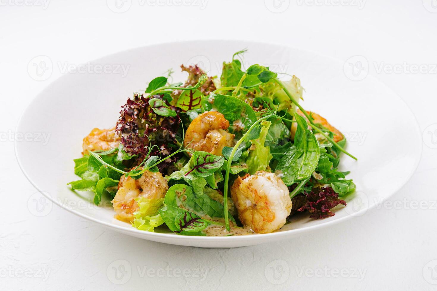 Prawn salad on white plate isolated photo