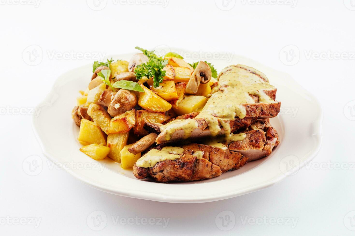 Plate with fried pork fillet, potato wedges, mushrooms photo