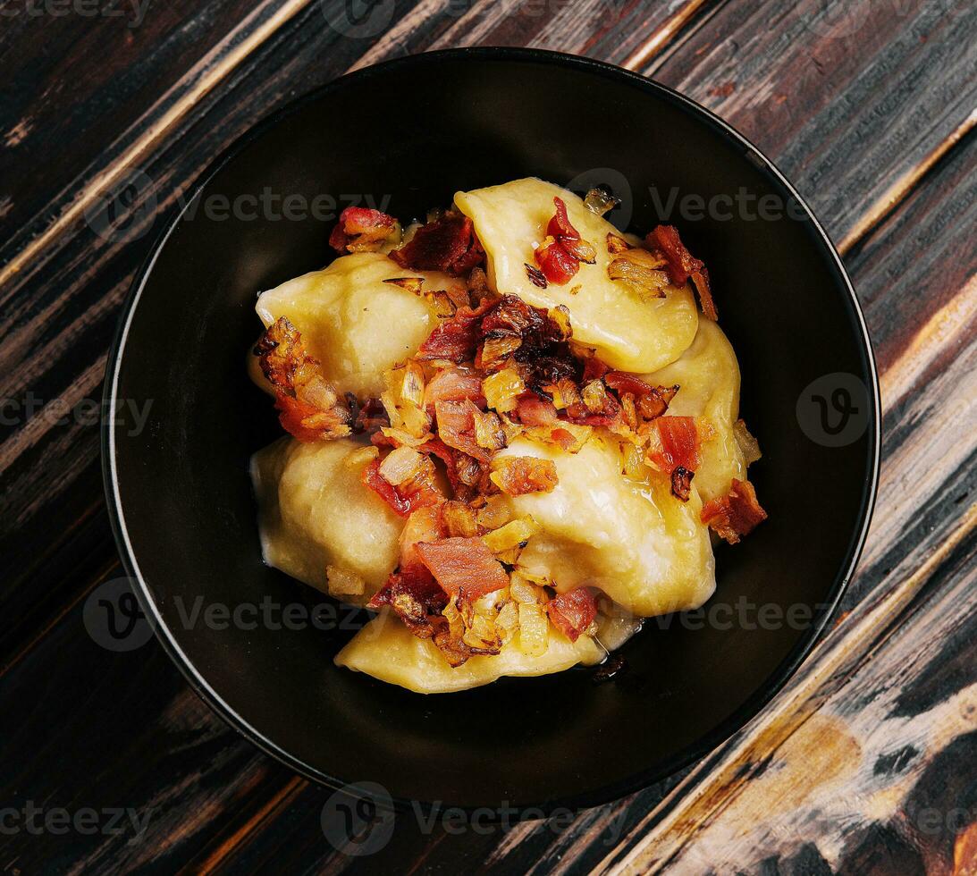 Baked potato dumplings with fried bacon and onions photo