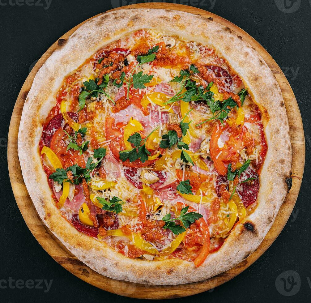 Fresh delicious pizza made in a hearth oven with sausage, pepper and tomatoes photo