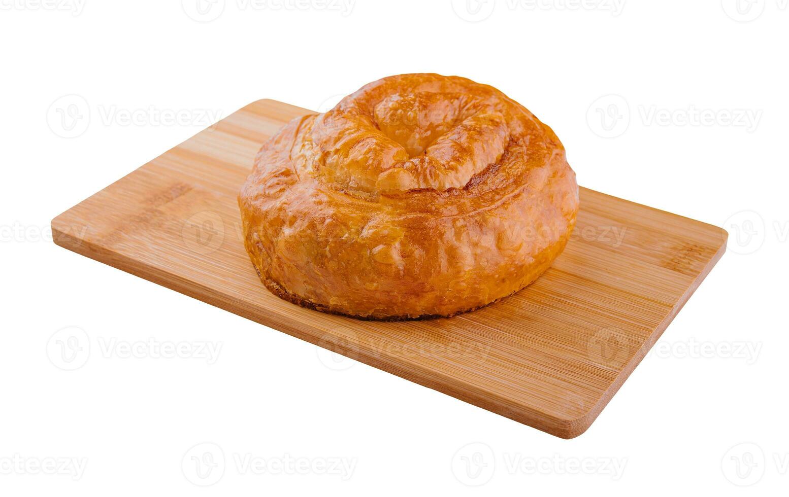 Fresh twisted bun on wooden board photo