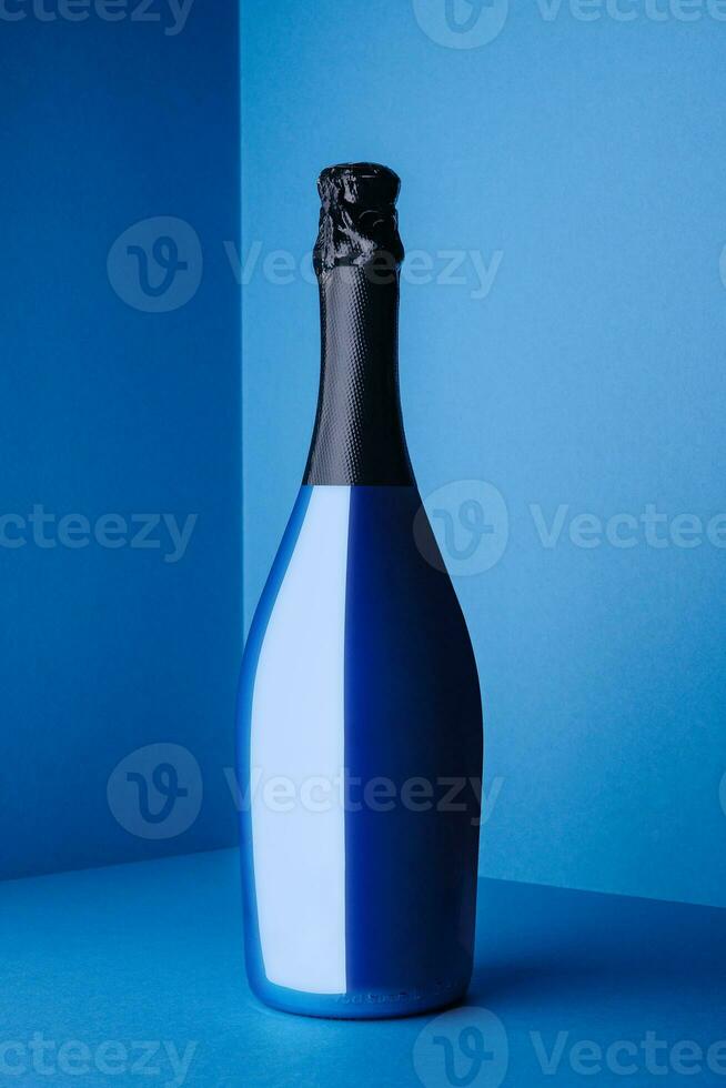 Blue Champagne bottle on light blue background photo