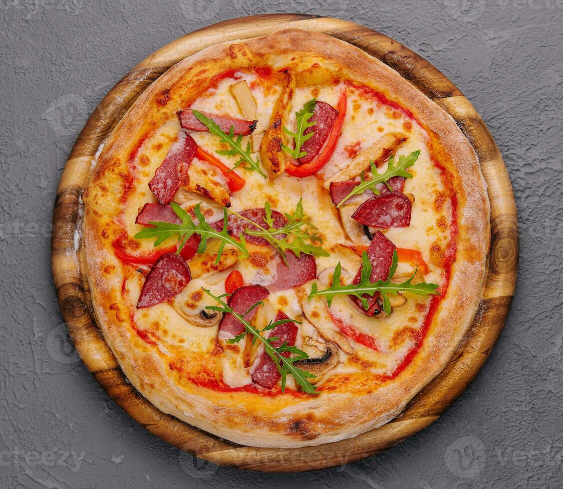 Fresh delicious pizza with three types of meat and sausage photo