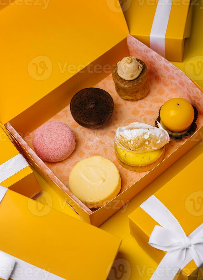 different mousses cakes in gift boxes photo