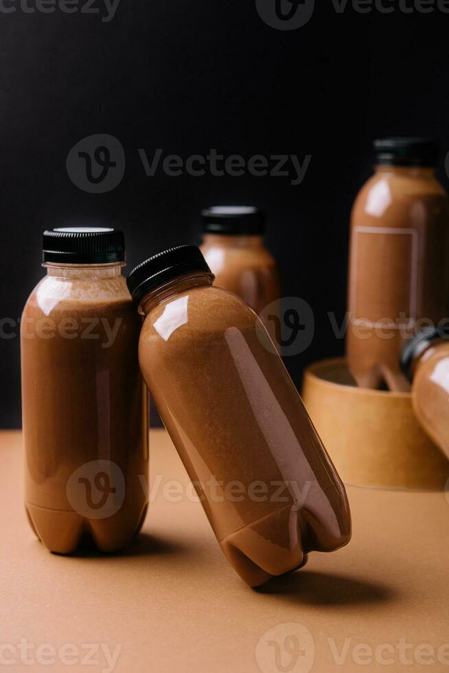 chocolate smoothies milkshake in bottles on black and brown background photo