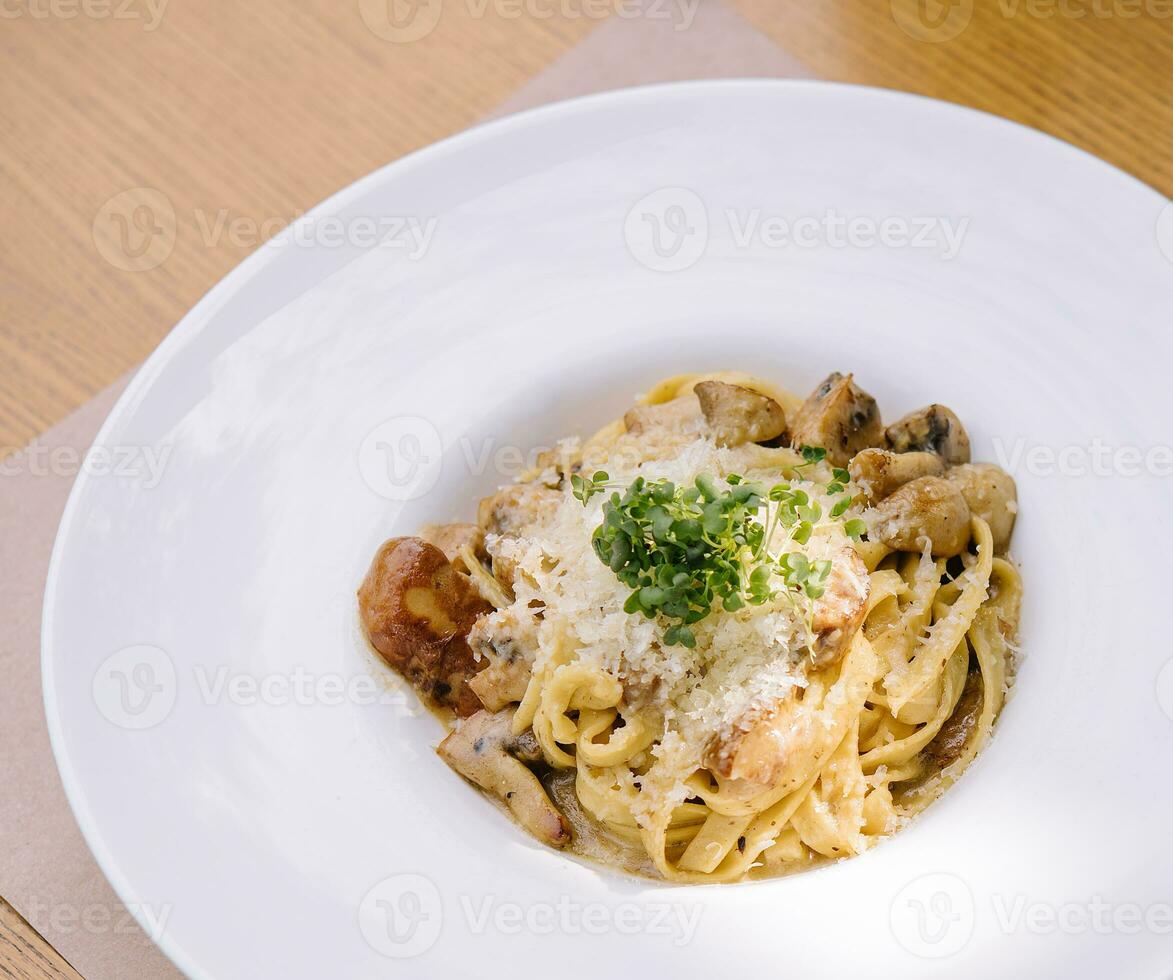 Delicious pasta with mushrooms and cheese in bowl photo