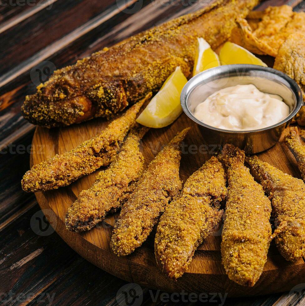 frito peces conjunto en de madera tablero foto