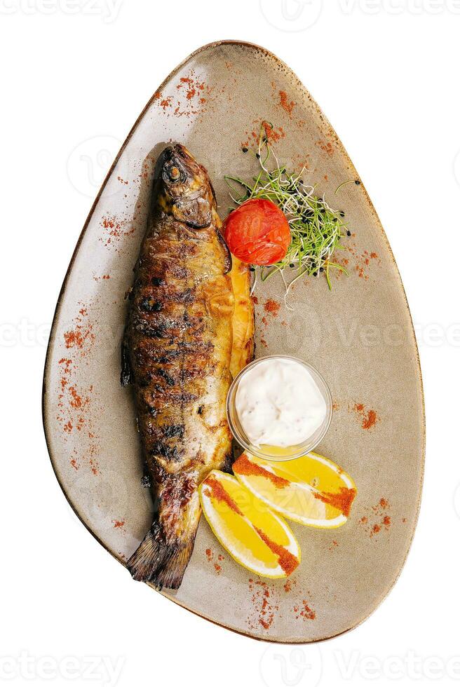 Grilled sea fish with lemon on plate photo