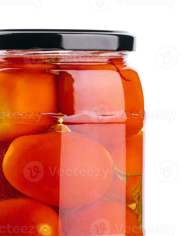 Pickled tomatoes in glass jar on white background photo