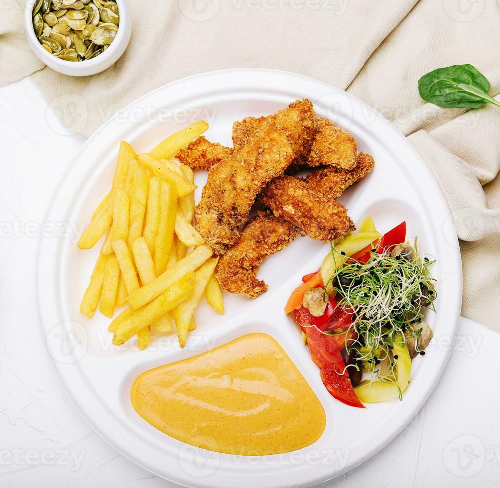 Chicken nuggets with french fries and mustard sauce photo