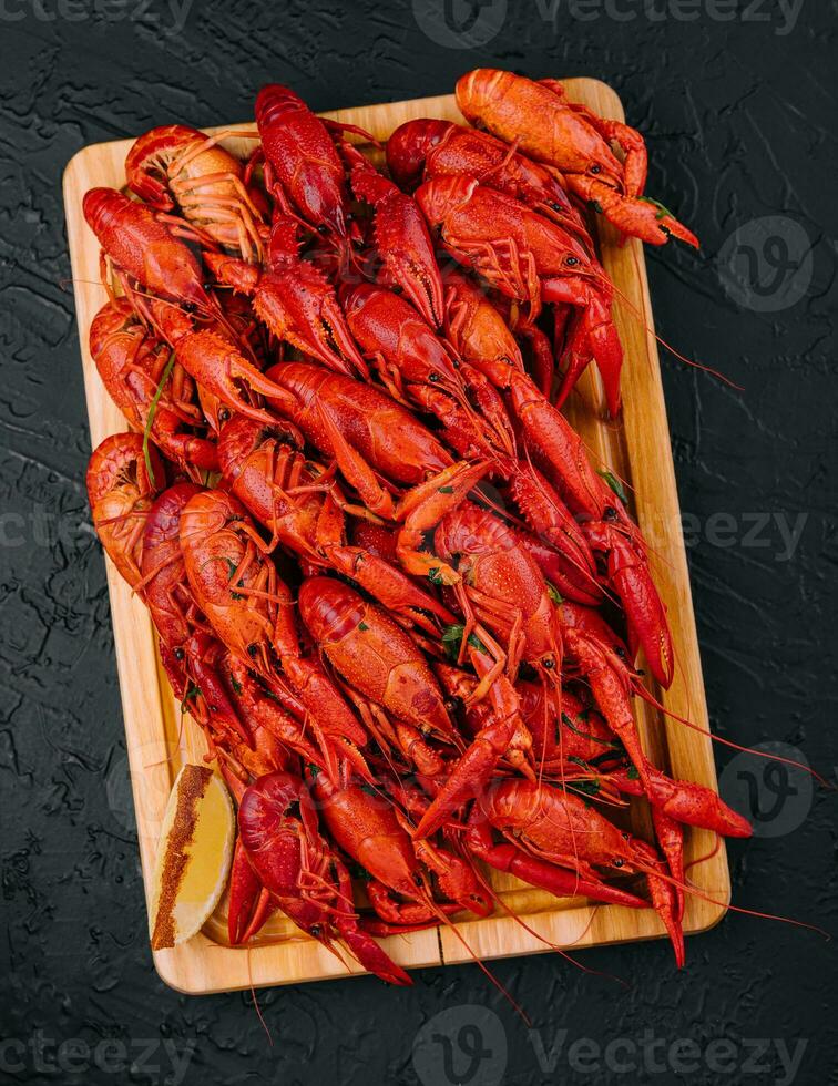 Fragrant boiled crayfish on a wooden board photo