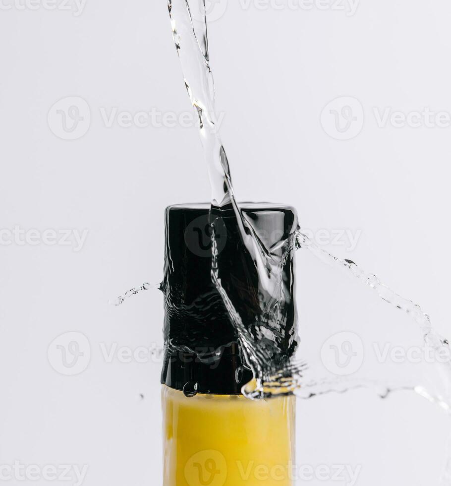 Bottle of shampoo splashing water and bubbles photo