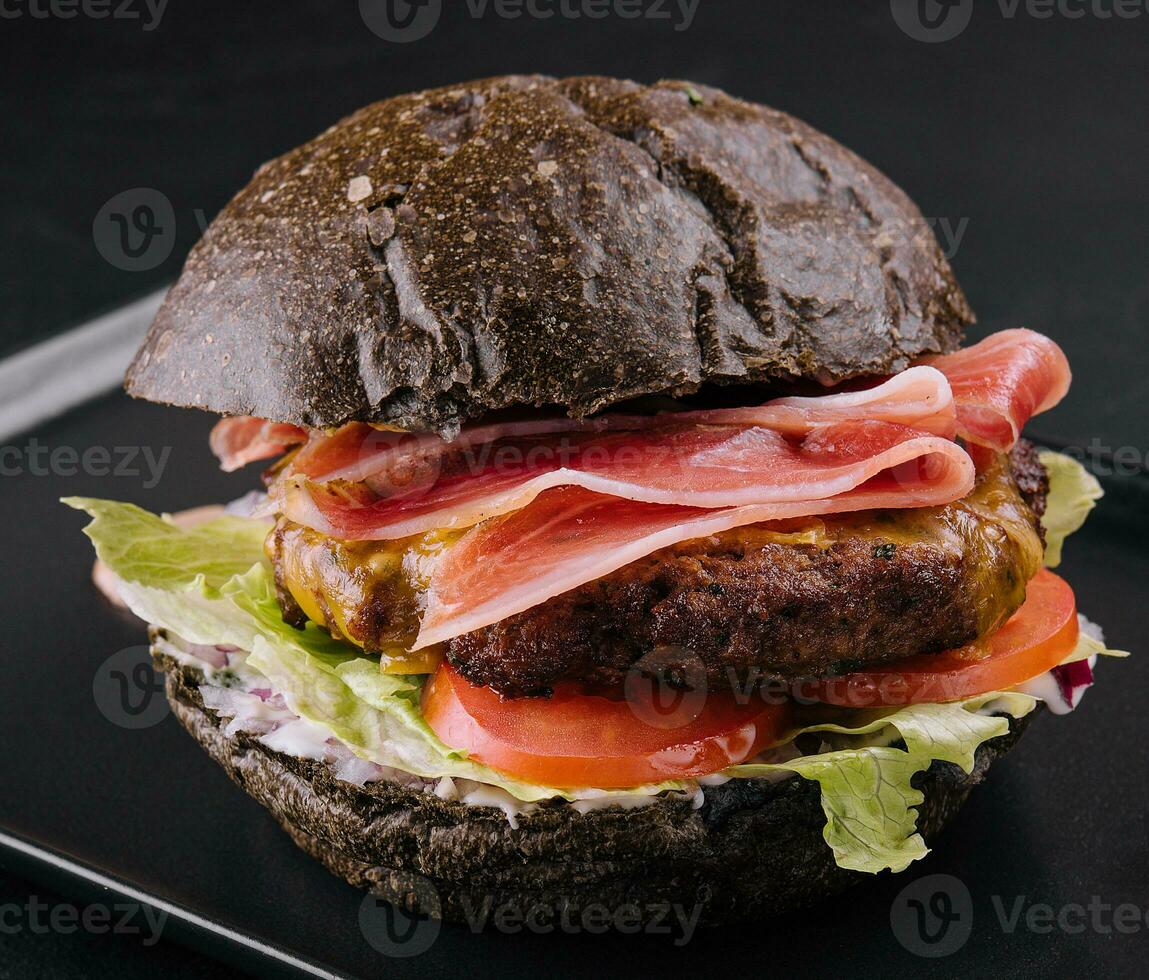 Modern black burger with prosciutto ham photo