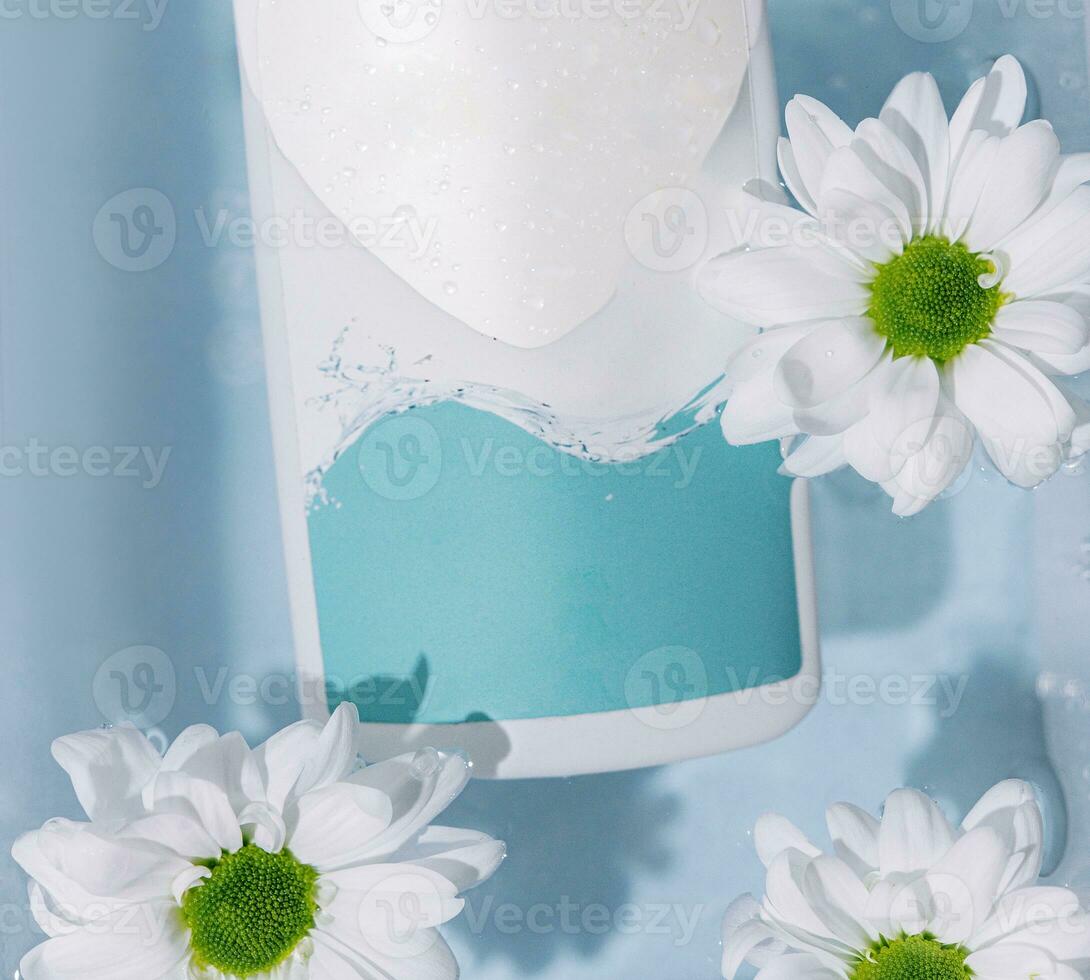 shampoo or skin care products and chamomile flowers on a white surface with clear water photo