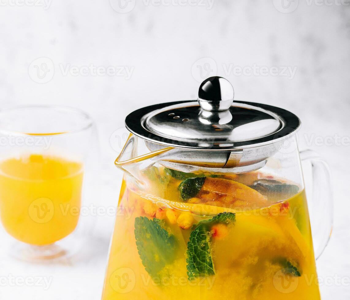 tea with mint and orange. aromatic hot drink in glass jar. photo