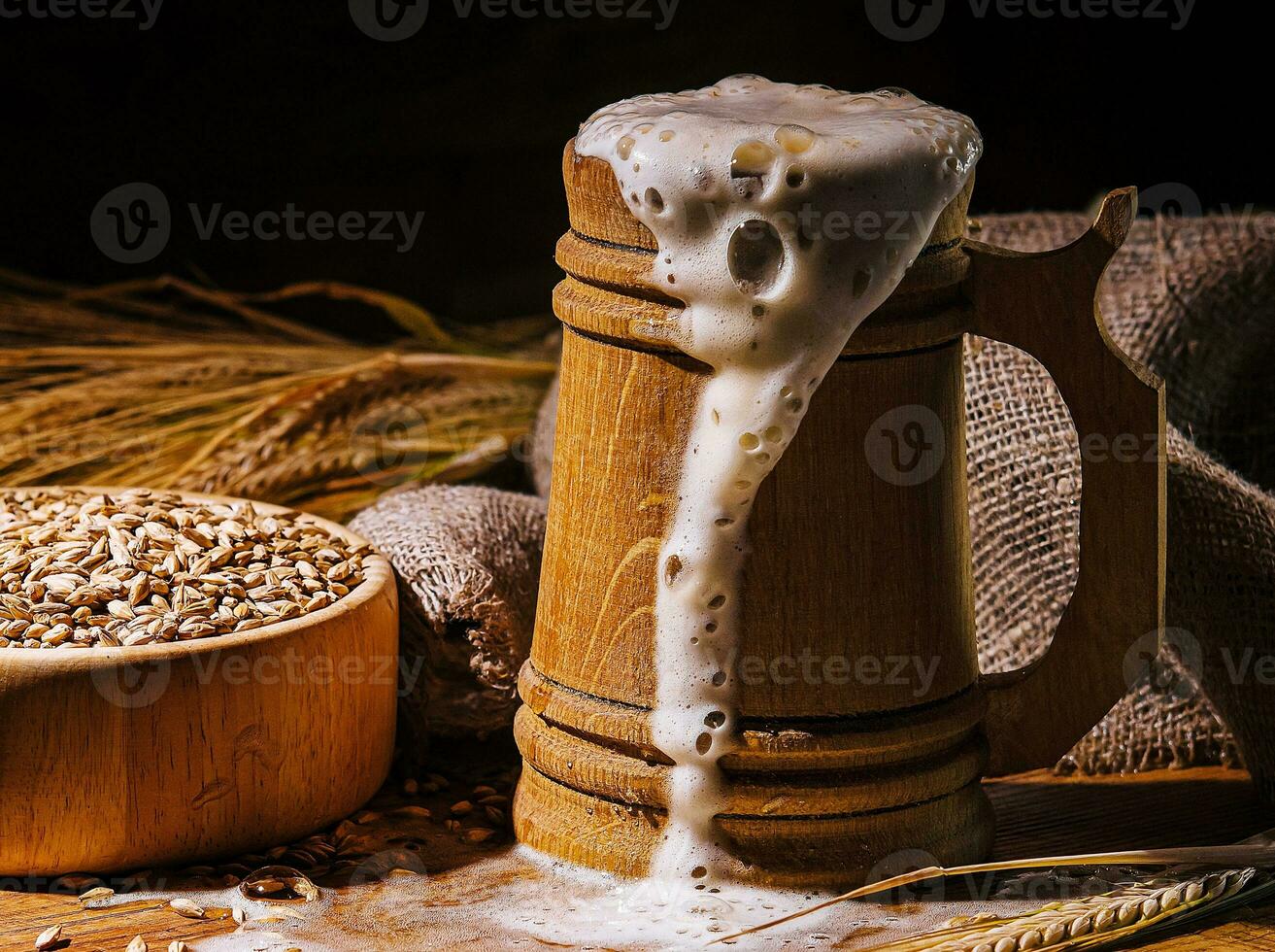Wooden beer mug with beer and foam standing on a wooden table photo