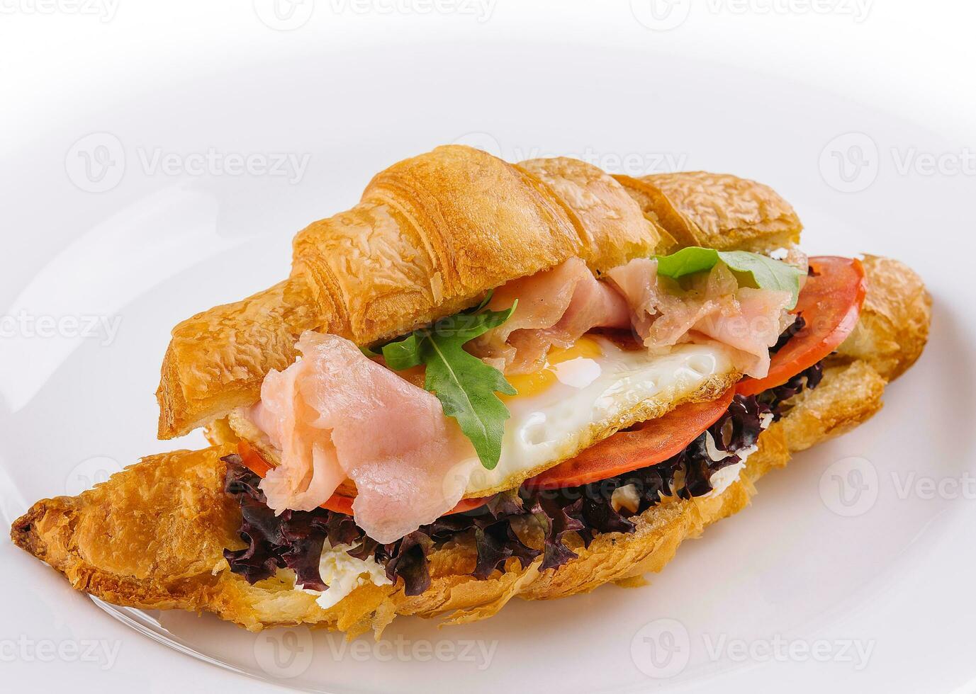 breakfast with croissant sandwiches with fried egg and salmon photo