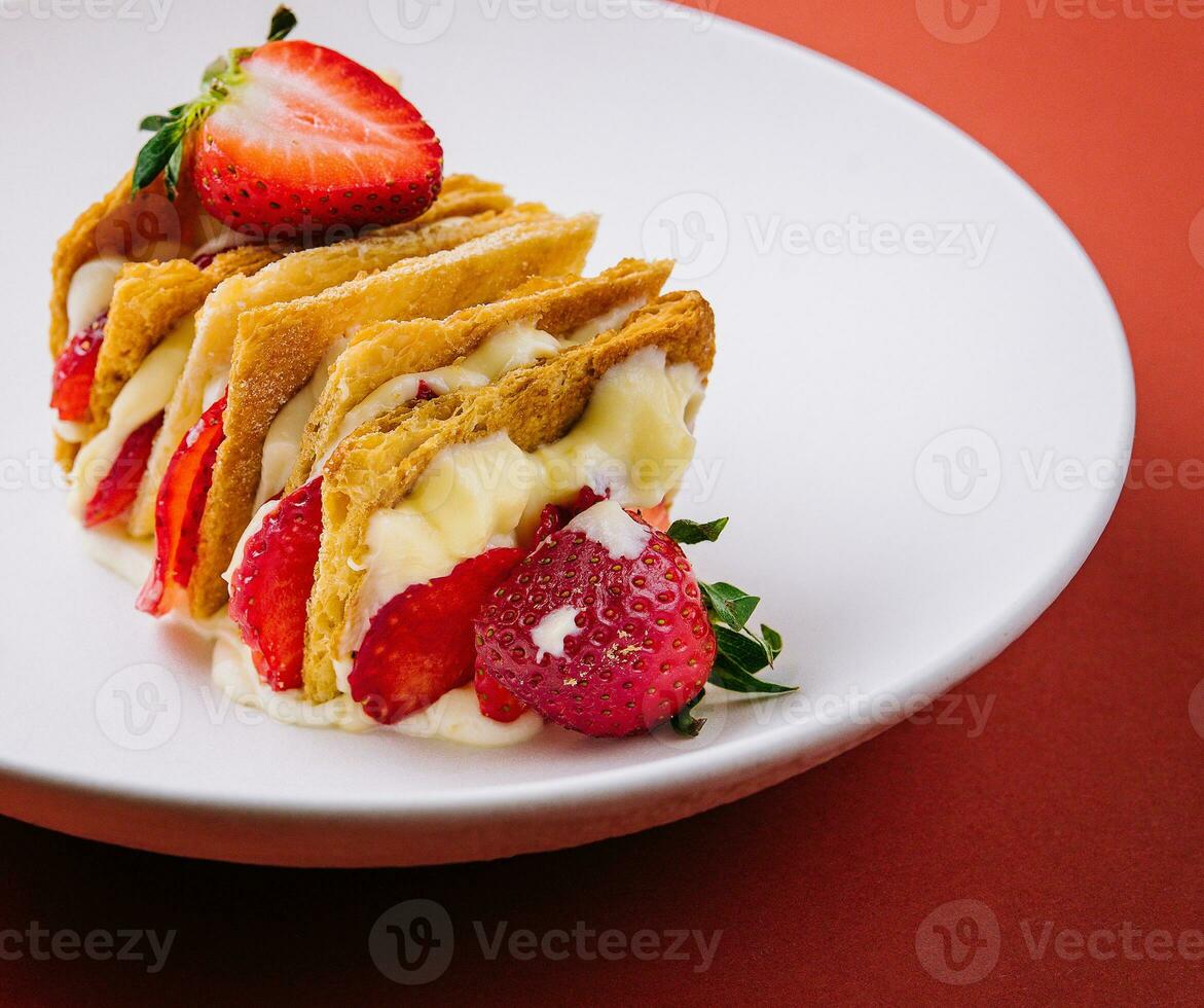 Strawberries and cream mille feuille dessert on plate photo