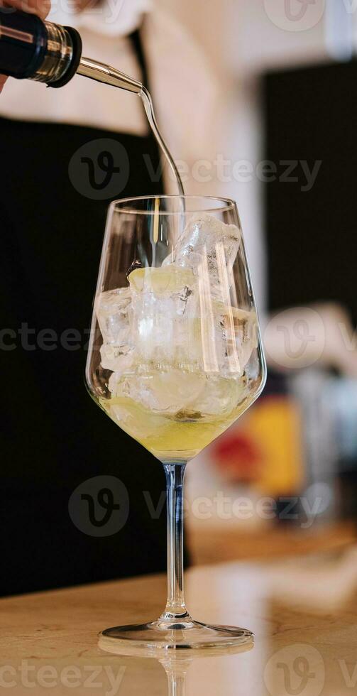 bartender pours alcohol into a glass photo