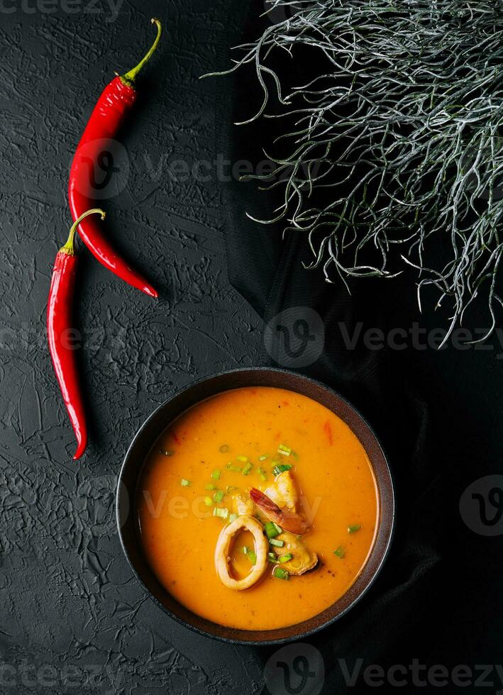 Tom yam seafood soup from above on black stone photo