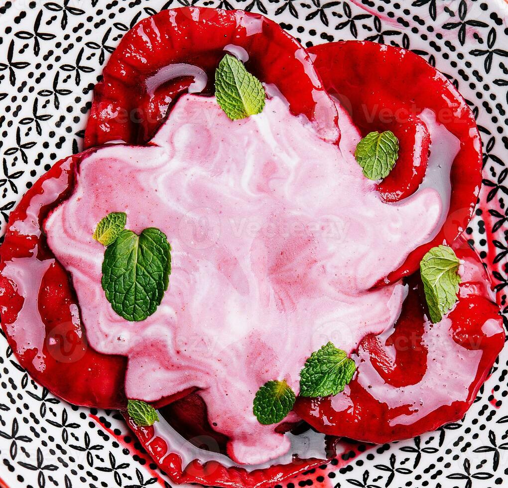 Vegan red ravioli with beetroot on a plate in cream sauce photo