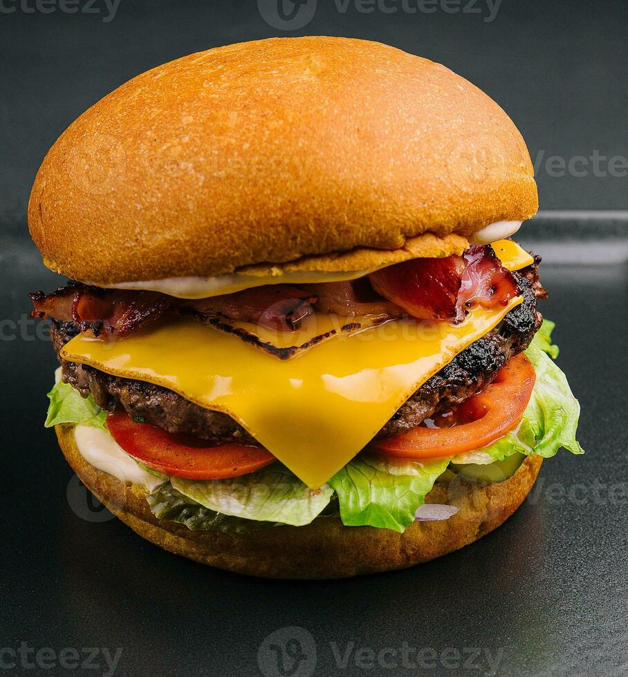 Bacon burger with beef patty on black tray photo