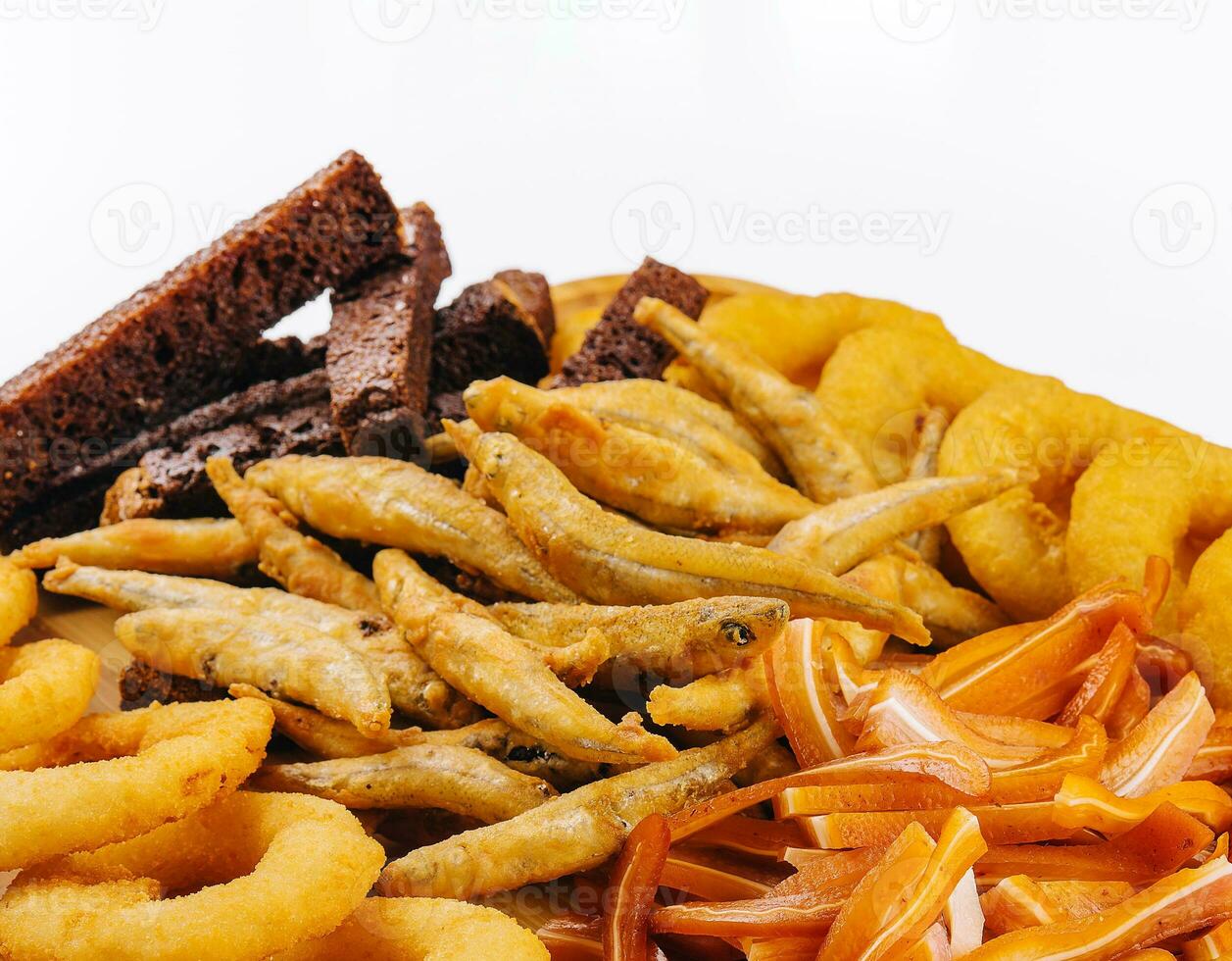 onion rings, fried smelt, pork ears on board photo