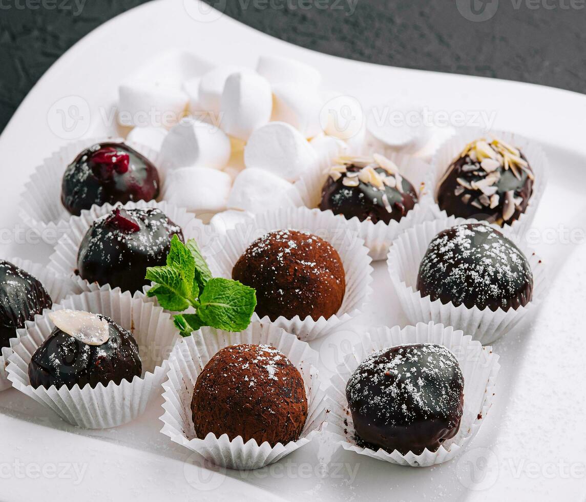 Boxes with tasty chocolate candies with marshmallow photo