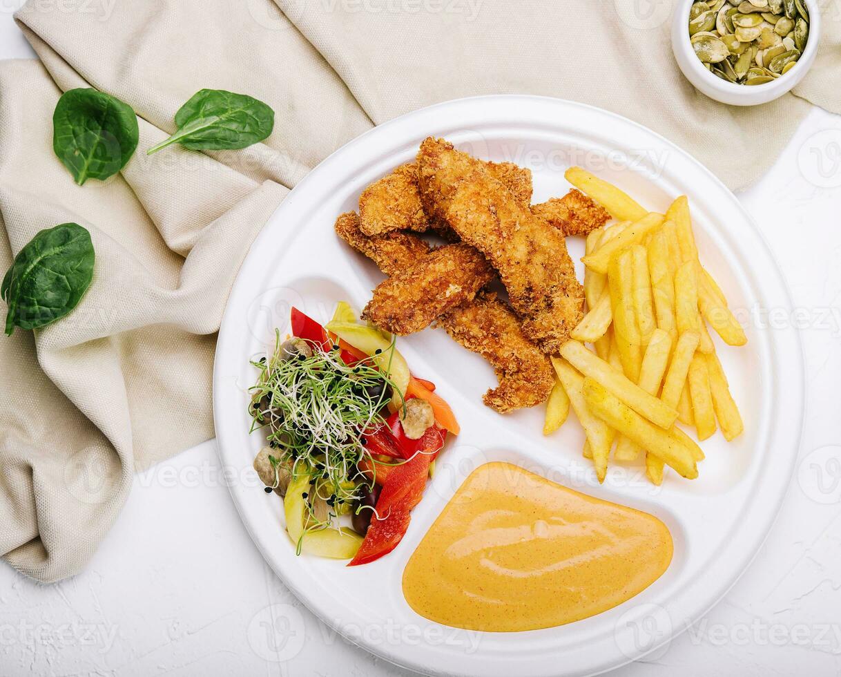 Chicken nuggets with french fries and mustard sauce photo