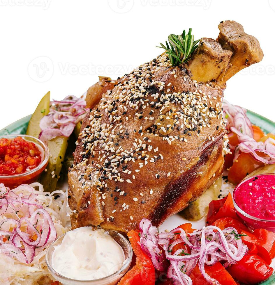 Tasty pork knuckle with sauces and vegetables photo