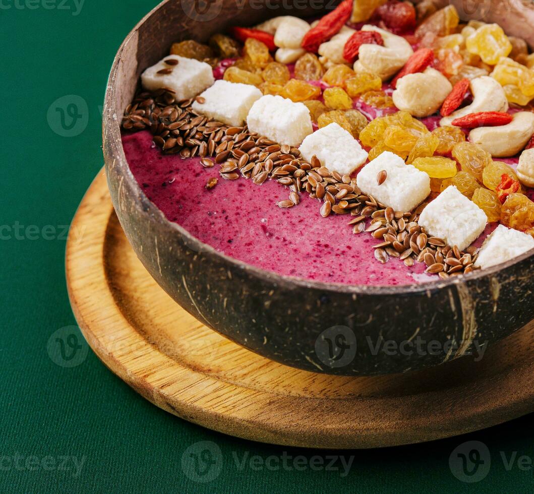 Healthy breakfast raisins and cashew nuts smoothie in coconut bowl photo