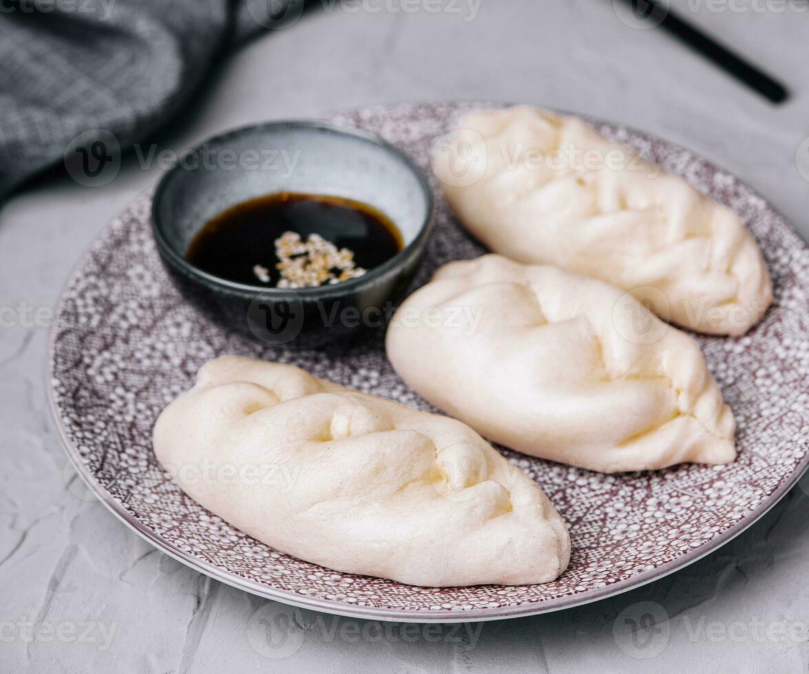 uncooked asian dumplings with soy sauce photo