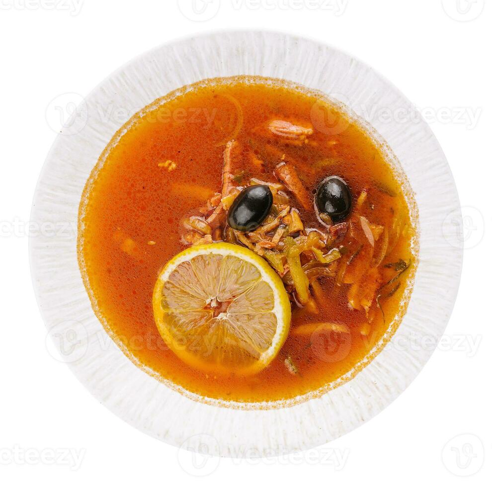 Solyanka mix soup with sausages, olives and lemon photo